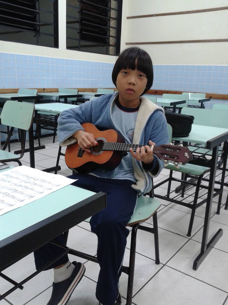 O aluno Lucas Kenji gosta de estudar com a mãe, que toca violão.